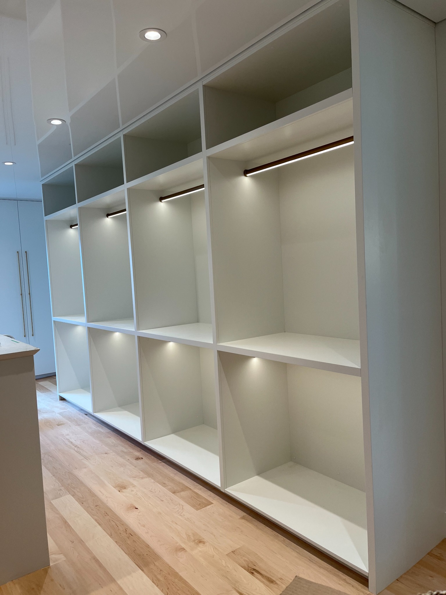 Floor-to-ceiling white display shelving with integrated lighting