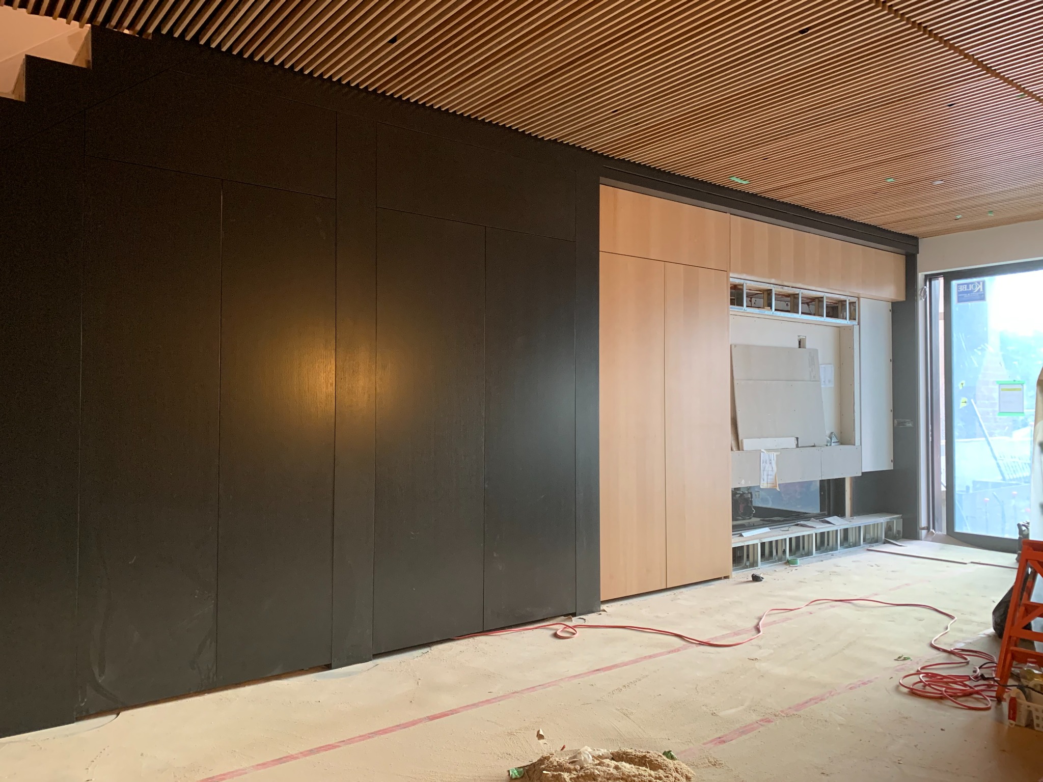 Two-tone integrated wall millwork with dark panels and light wood cabinetry